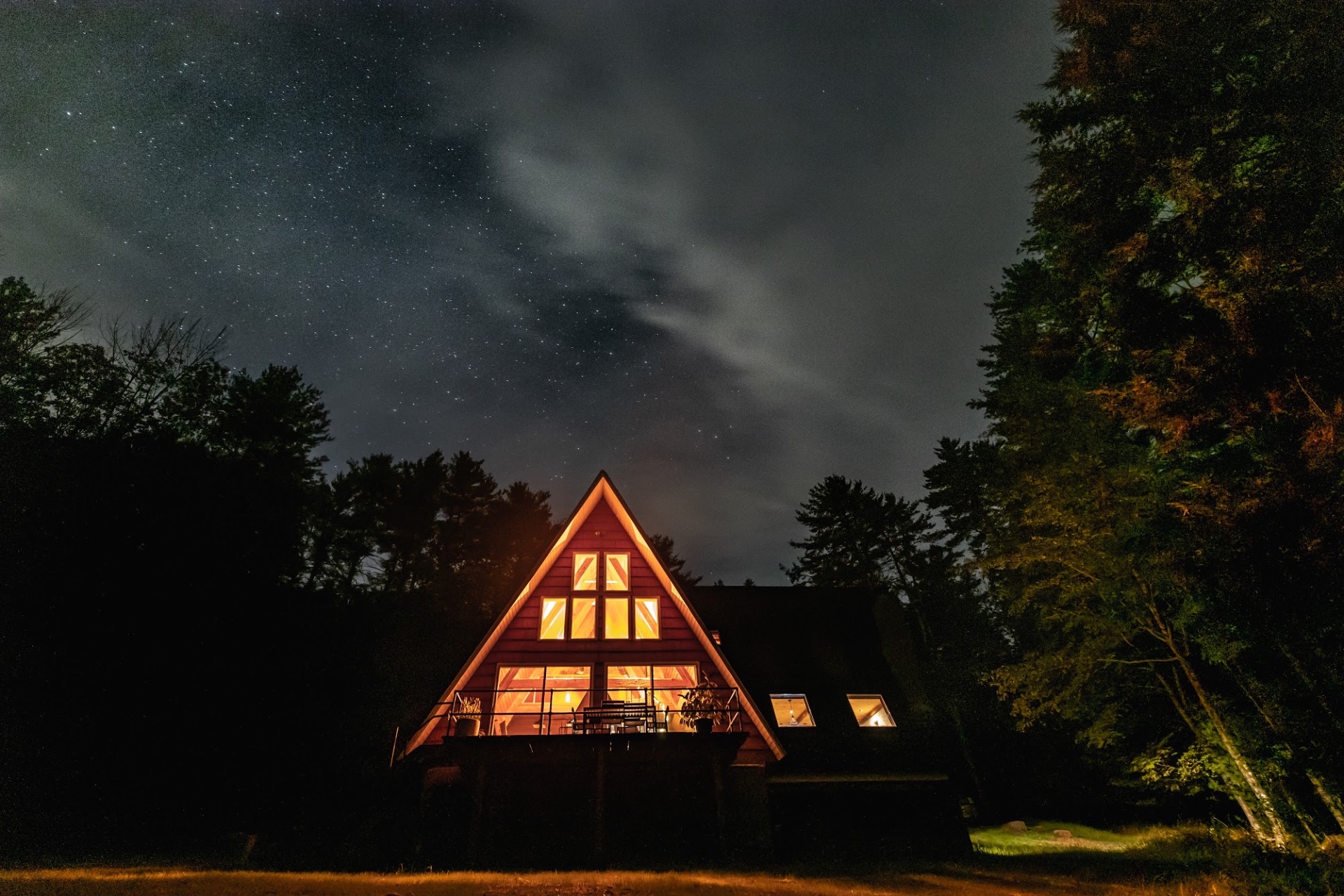 Thaddeus House — a hand-built A-frame cabin glowing at dusk in the Catskills